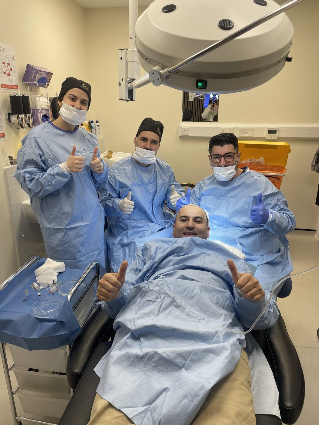 Tower Bridge Hospital London surgical team with patient in theatre after hair transplant procedure